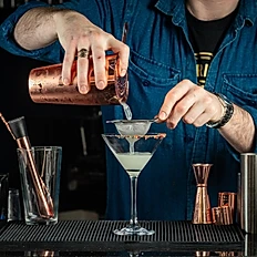 Man pouring a magarita into cocktail glass